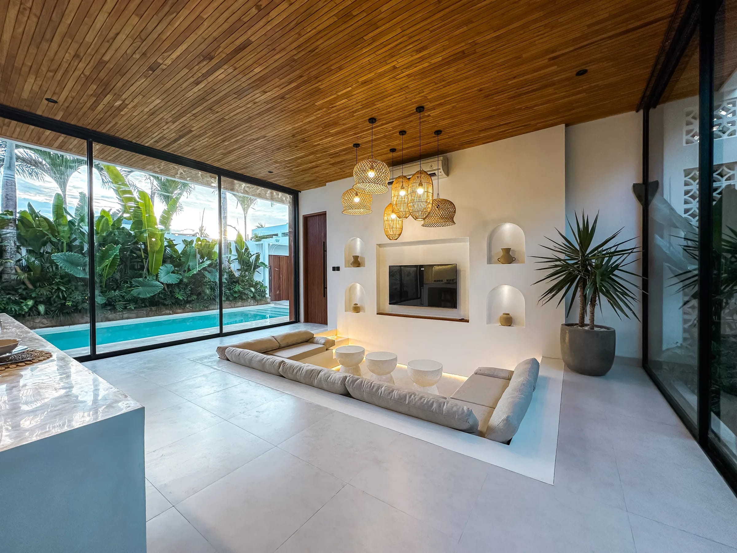 Casa Petak sunken lounge with full-height pool view and timber ceiling