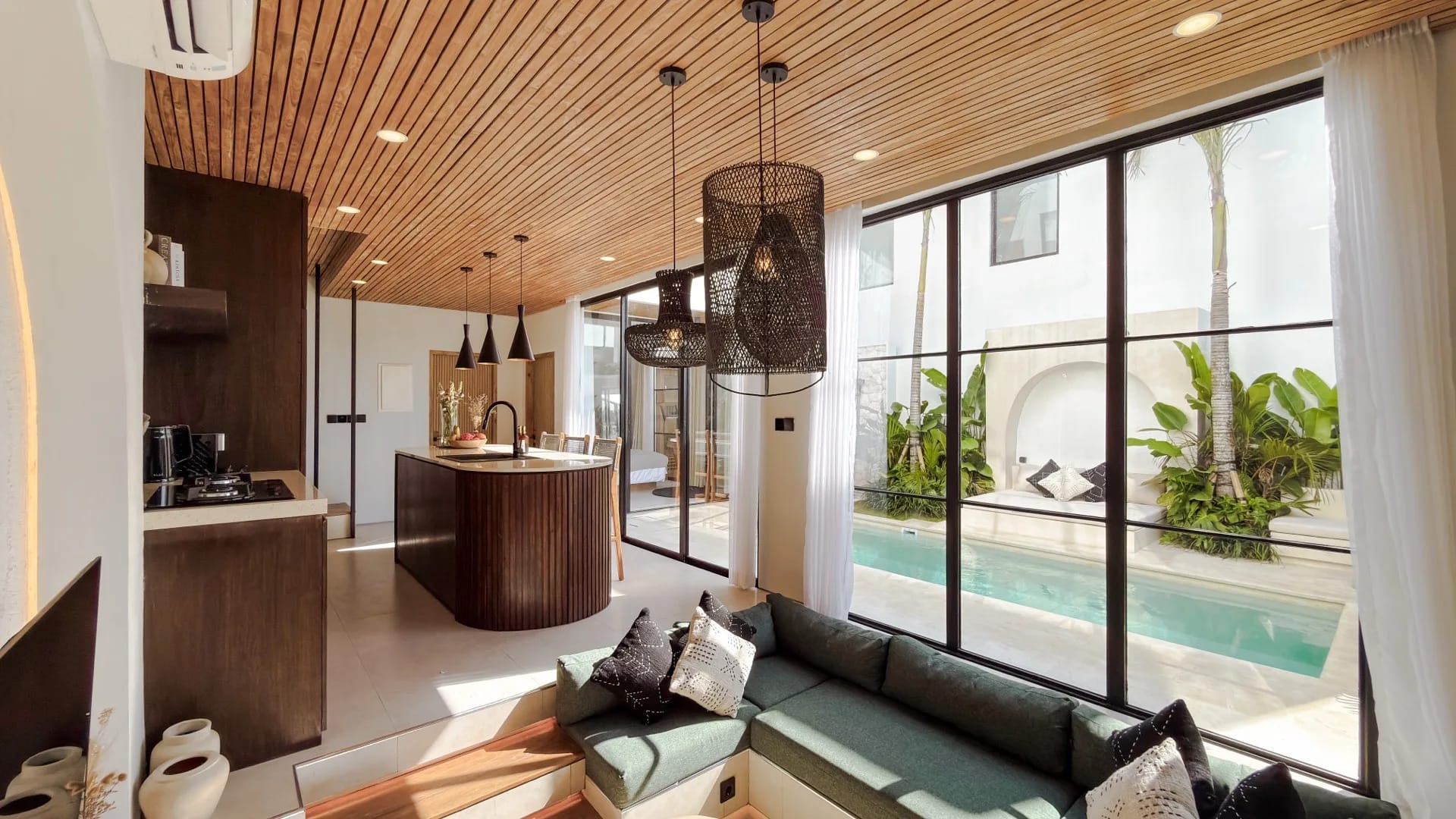 Solas Uluwatu sunken living lounge with a green banquette opening to the pool