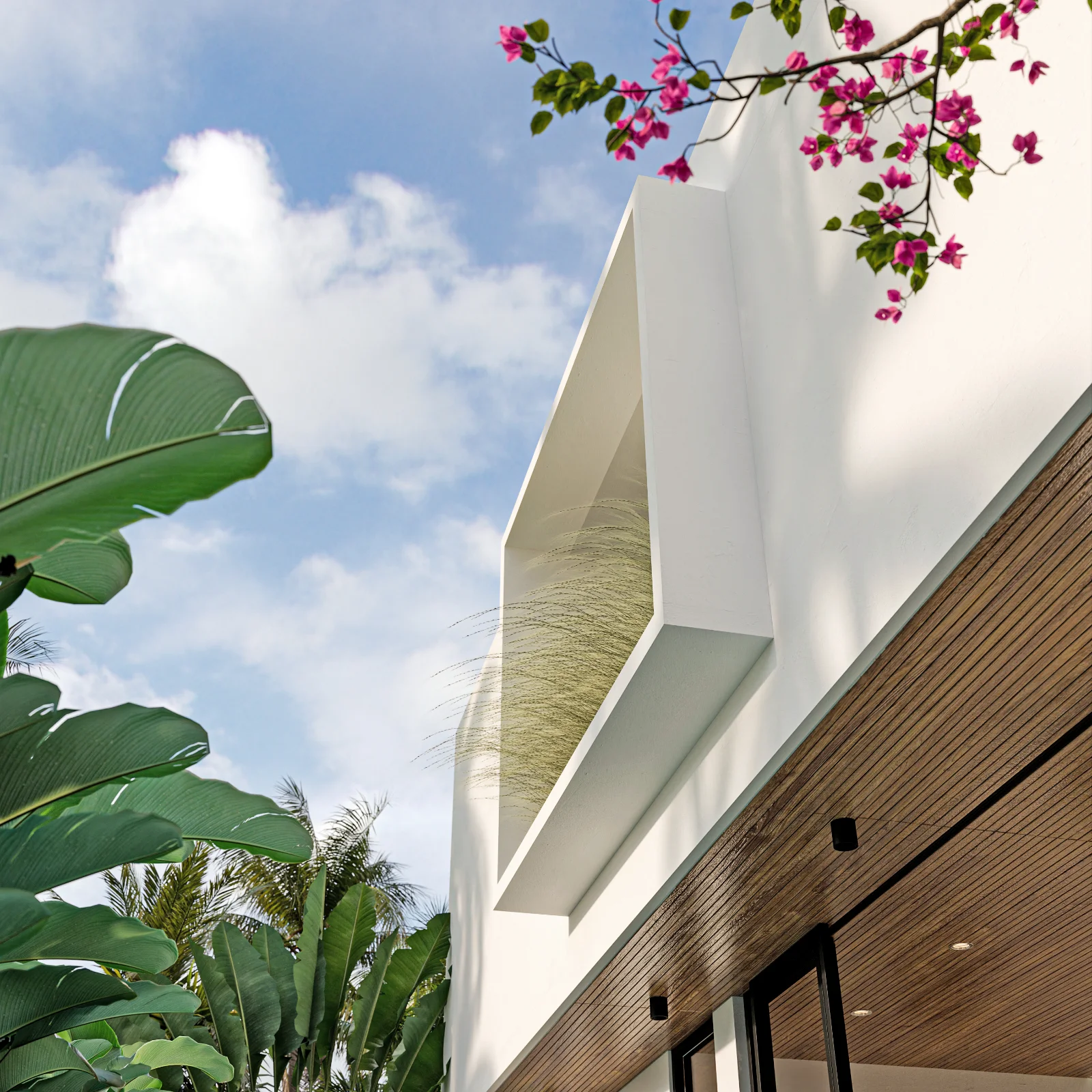 White facade detail with timber slats and bougainvillea at Umah Ubud