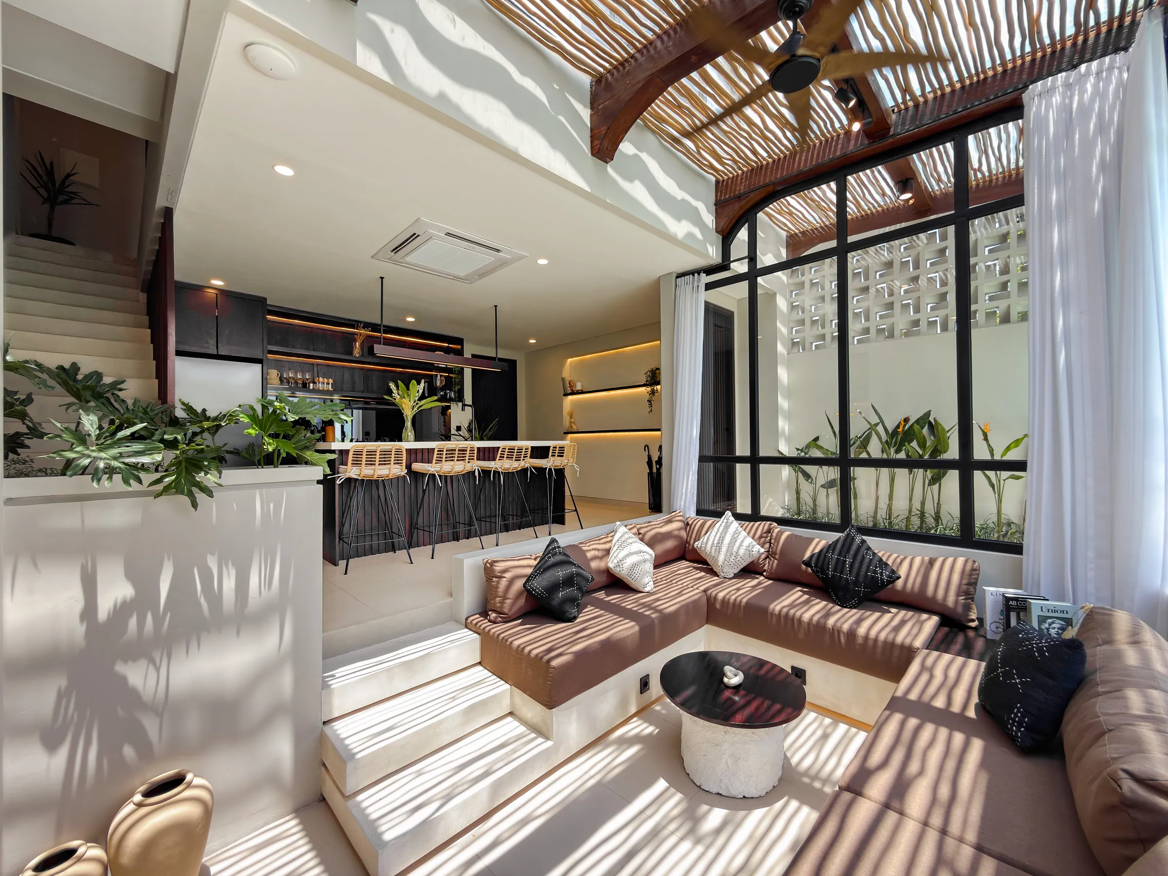 Open-plan ground floor with the sunken lounge, the kitchen and the stairs